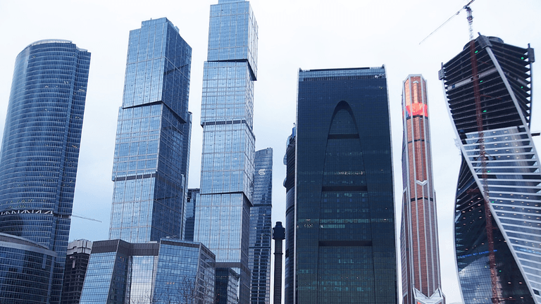 Modern skyscrapers with glass facades in a city skyline under a cloudy sky