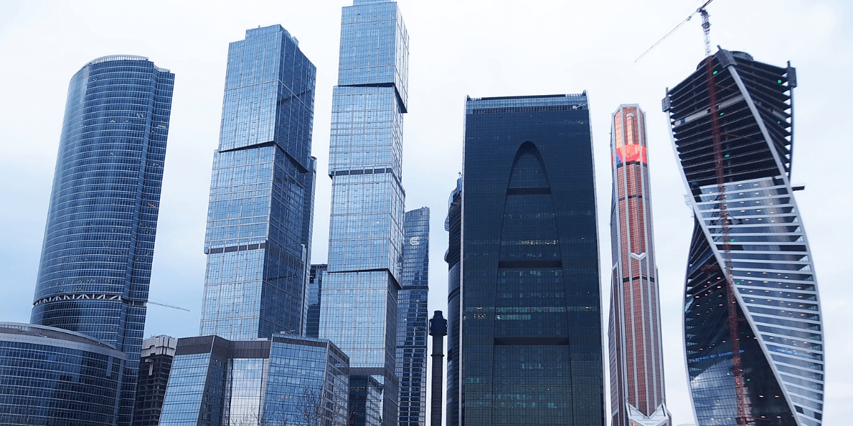 Modern skyscrapers with glass facades in a city skyline under a cloudy sky
