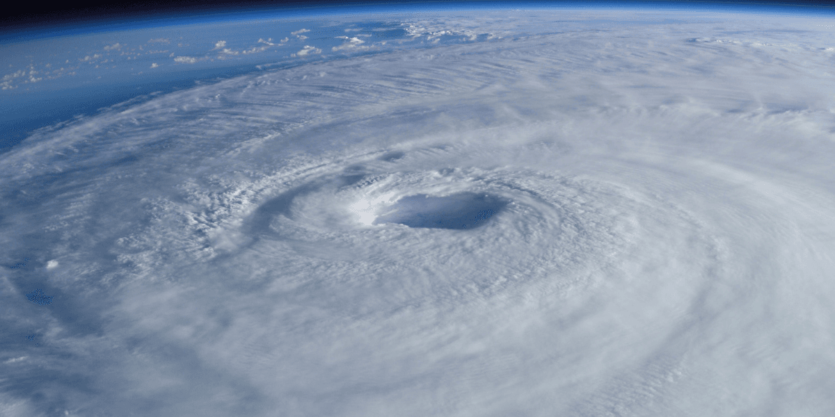 Aerial view of a swirling hurricane with a prominent eye and dense cloud cover