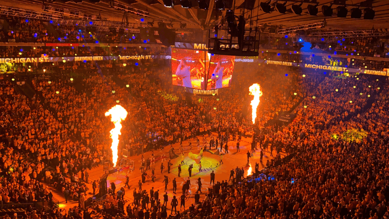 Fans fill an arena during NBA Summer League player introductions with flames and large video screens.