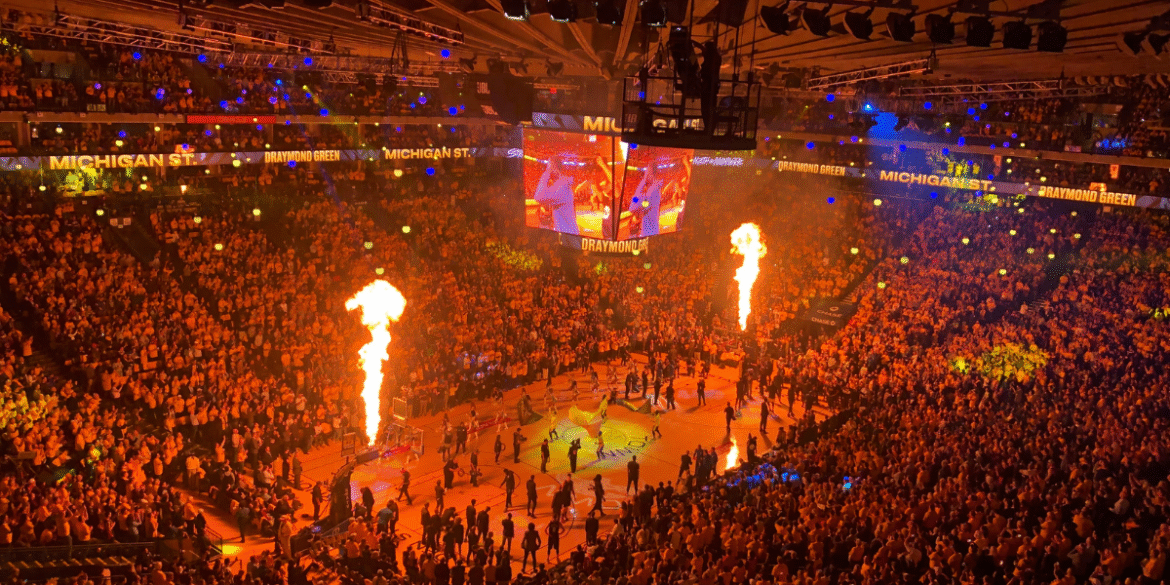 Fans fill an arena during NBA Summer League player introductions with flames and large video screens.