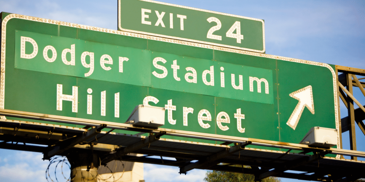 Green freeway sign directing traffic toward Dodger Stadium and Hill Street at Exit 24.